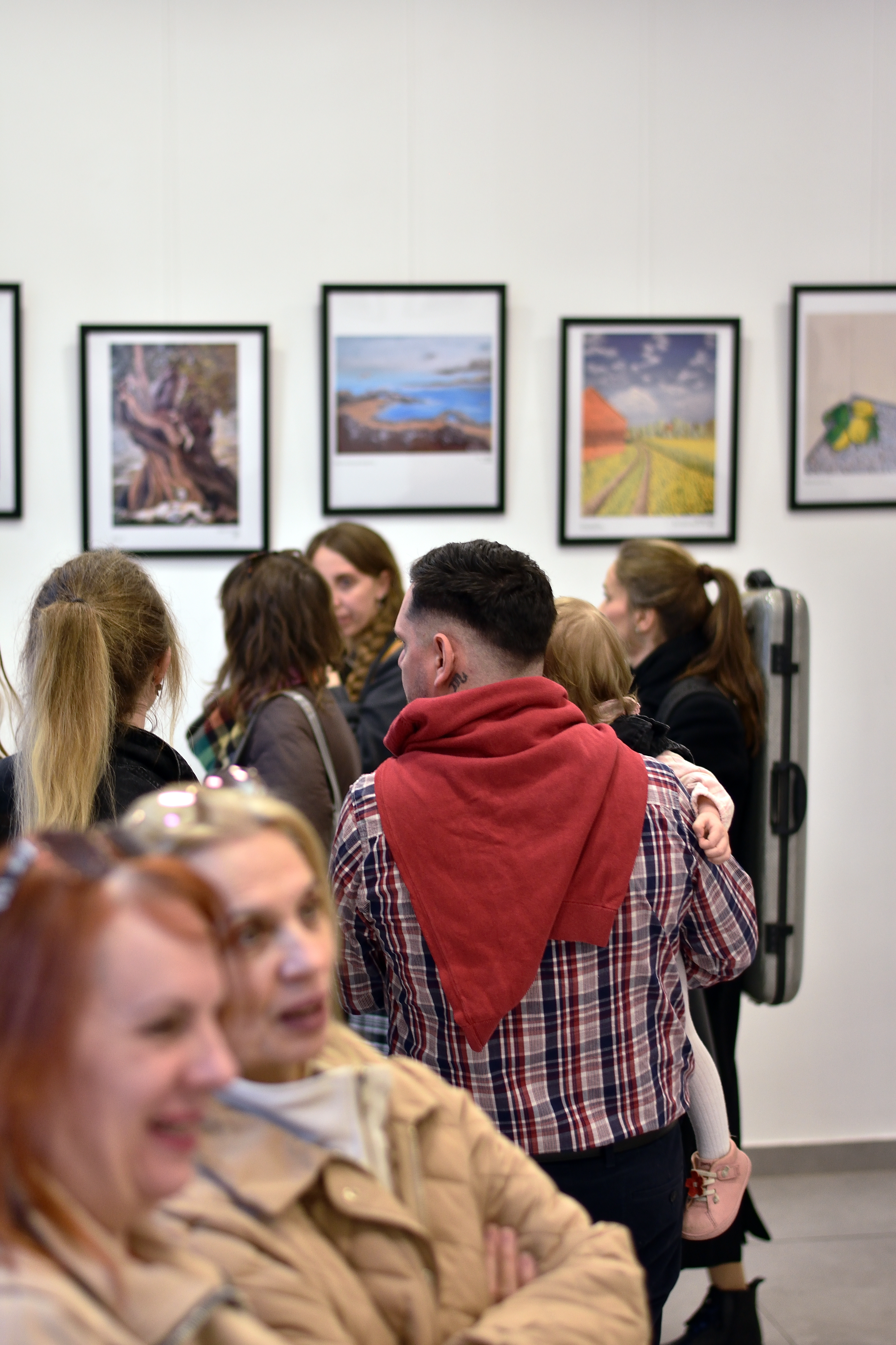 Visitors looking at framed artwork in Vienna gallery